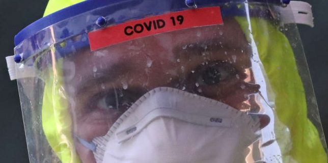 A firefighter in a full protective gear is pictured at an improvised car-wash site to disinfect an ambulance, after the transportation of a patient infected with coronavirus disease (COVID-19), in Brussels