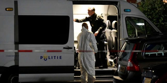 Forensic technician stands next to a police van following a shooting in Dordrecht