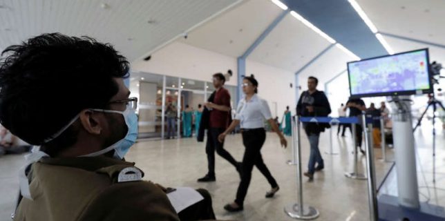 People wearing masks have their temperature scanned at Bandaranaike International Airport after Sri Lanka confirmed the first case of coronavirus in the country, in Katunayake