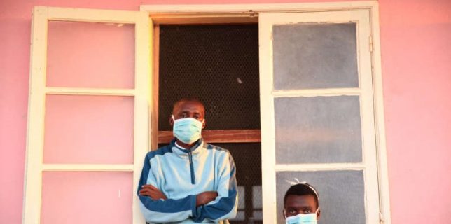 FILE PHOTO: Tuberculosis patients, wearing masks to stop the spread of the disease, stand outside their ward at Chiulo Hospital, Cunene province