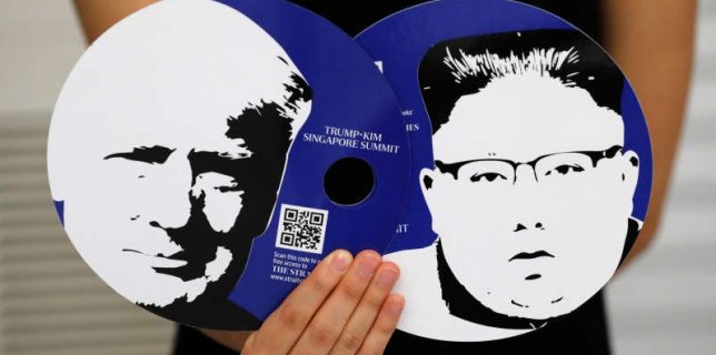 A worker of a media center for the summit between the U.S and North Korea shows fans featuring the images of U.S. President Donald Trump and North Korean leader Kim Jong Un,  which provided for journalists in a media kit at the media center in Singapore